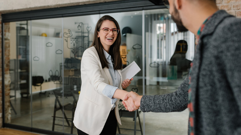 Career program student in suit shaking hands with a professional