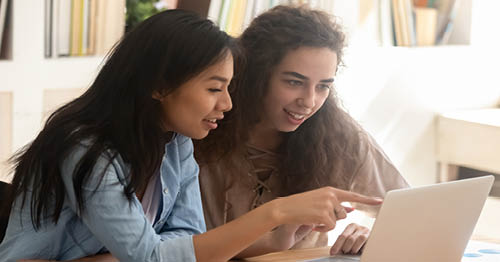 A group of online school students research summer jobs vs internships.
